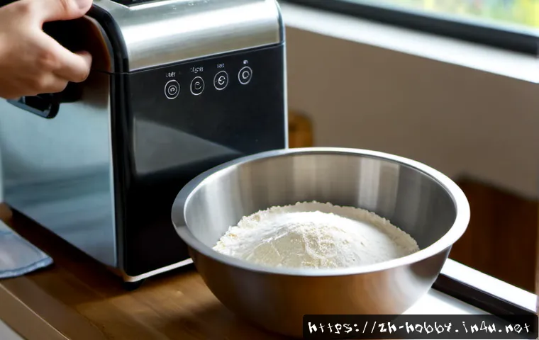 제빵기 사용법 - Photorealistic close-up of a modern stainless steel bread maker on a clean bright kitchen counter, a...